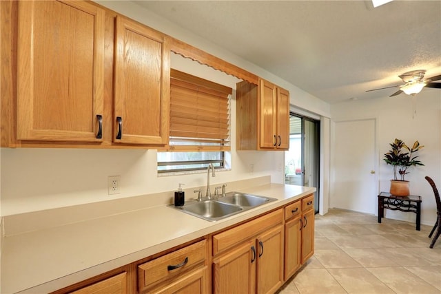 kitchen featuring a sink, light countertops, ceiling fan, and light tile patterned flooring