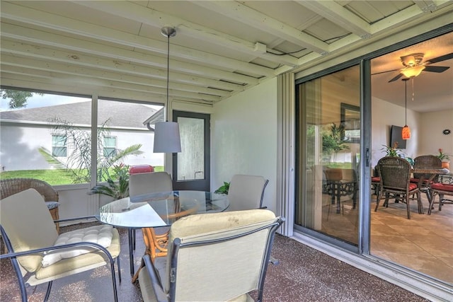 sunroom featuring outdoor dining space and a ceiling fan