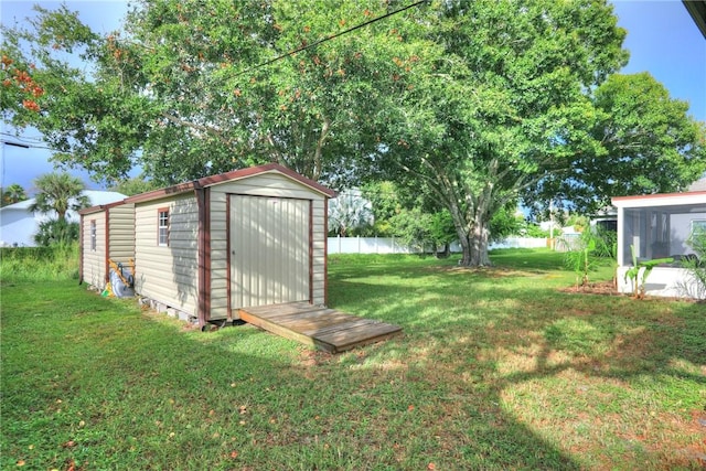 view of yard with fence, an outbuilding, and a storage unit