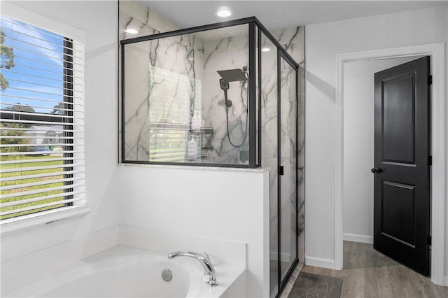 bathroom featuring plus walk in shower and hardwood / wood-style flooring