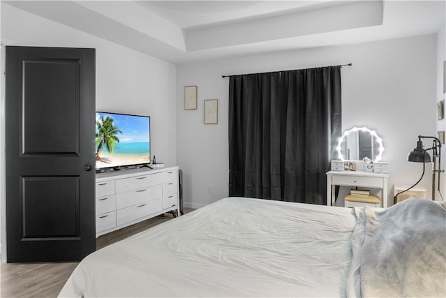 bedroom featuring dark hardwood / wood-style floors and a raised ceiling