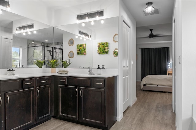 bathroom with an enclosed shower, wood-type flooring, ceiling fan, and vanity