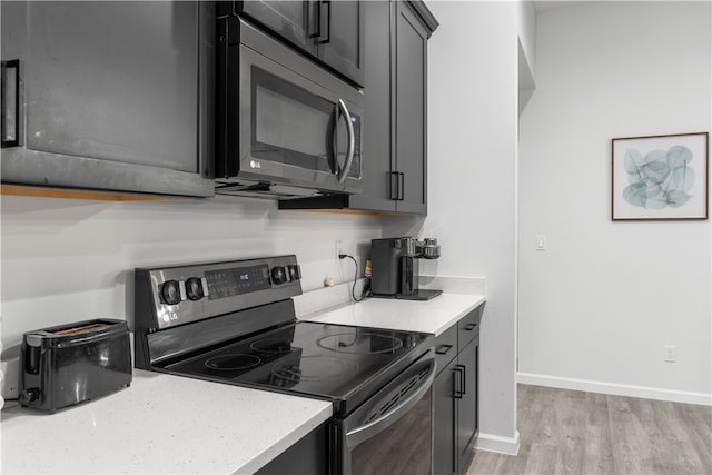 kitchen featuring black range with electric cooktop and light hardwood / wood-style floors