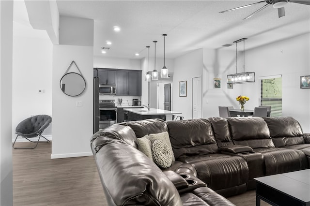 living room featuring a textured ceiling, dark hardwood / wood-style floors, ceiling fan, and sink