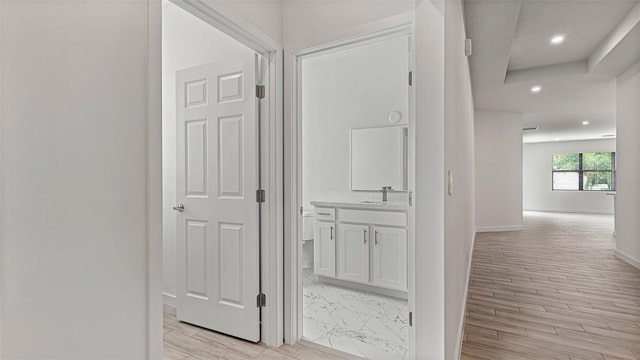 hallway featuring sink and light hardwood / wood-style floors