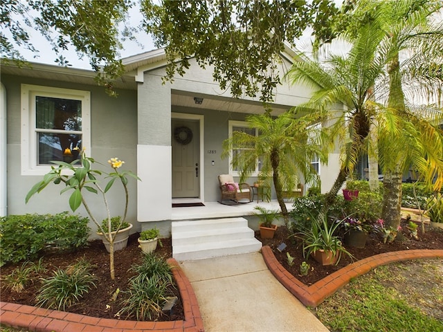 view of exterior entry featuring covered porch