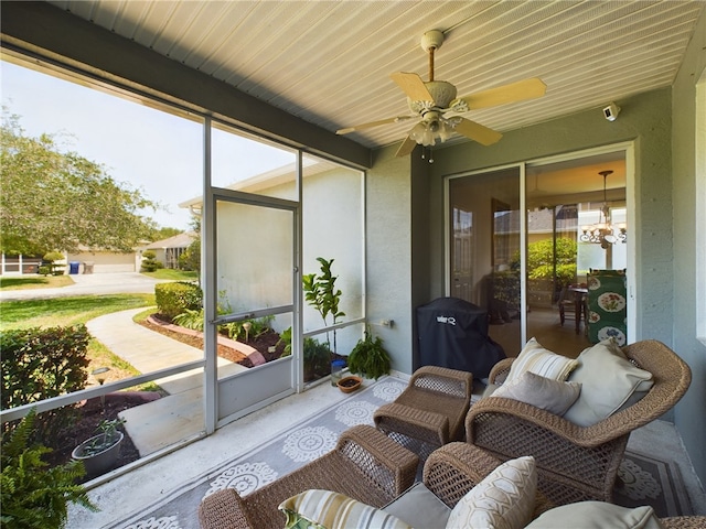 sunroom / solarium with ceiling fan with notable chandelier and plenty of natural light