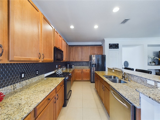 kitchen featuring sink, black appliances, ornamental molding, tasteful backsplash, and light stone countertops