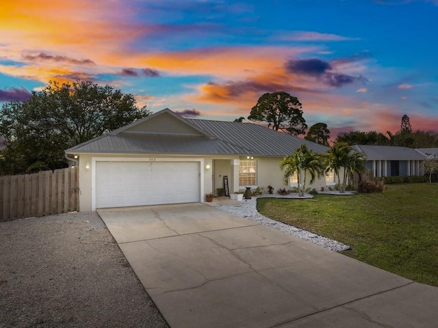 ranch-style house featuring a garage and a yard