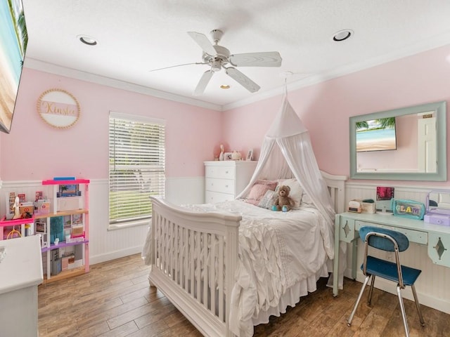 bedroom featuring hardwood / wood-style flooring, ceiling fan, and ornamental molding