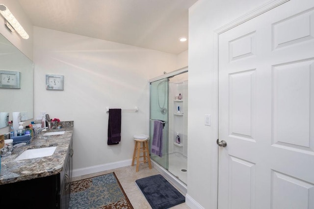 bathroom featuring a shower with door, vanity, and tile patterned floors