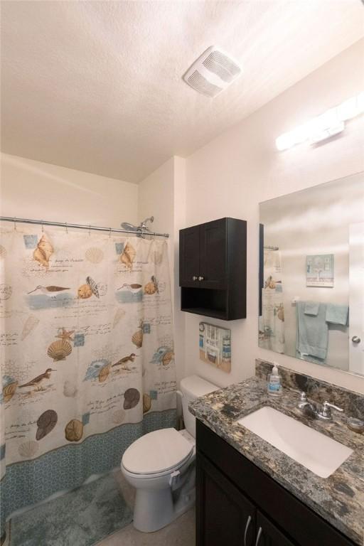 bathroom featuring vanity, a shower with shower curtain, a textured ceiling, and toilet