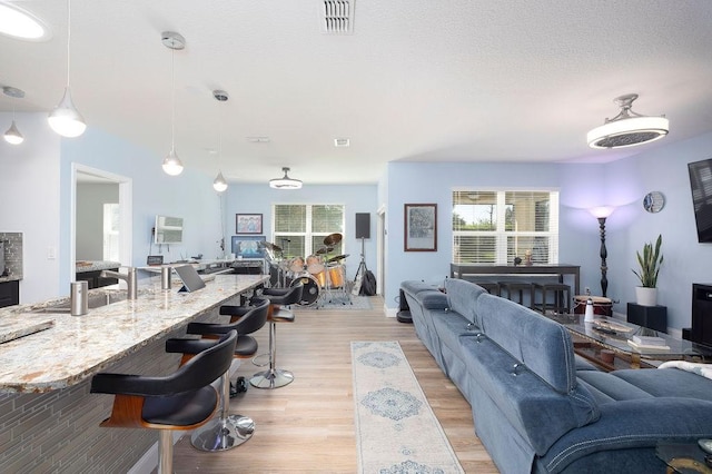 living room with a textured ceiling and light hardwood / wood-style flooring