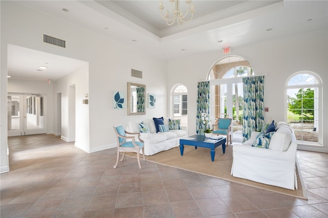 living room with a high ceiling, an inviting chandelier, and french doors