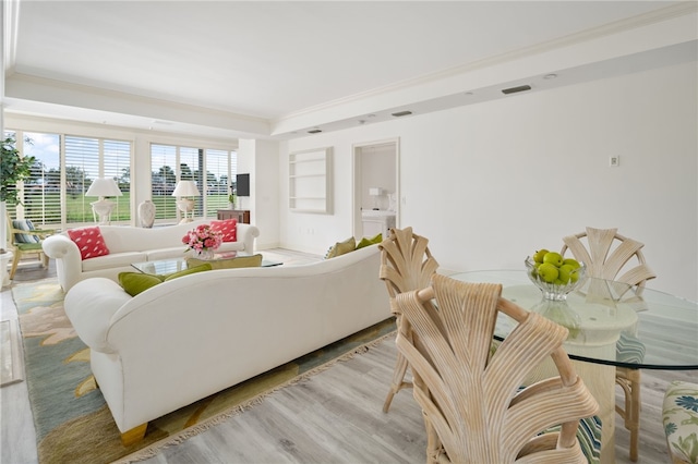 living room with light wood-type flooring and crown molding