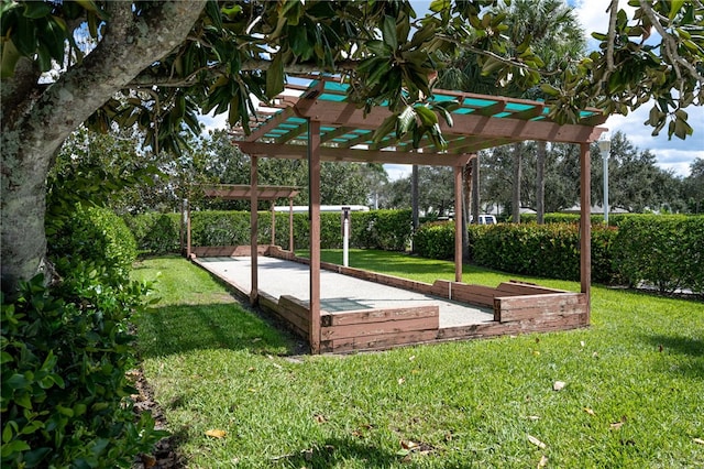 view of property's community with a yard and a pergola