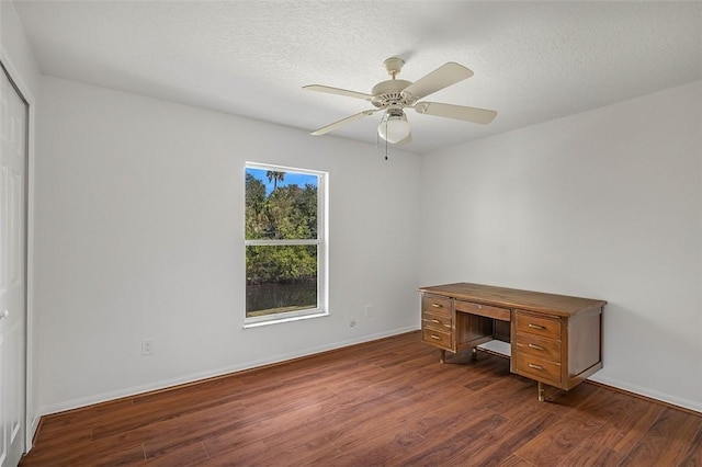 unfurnished office featuring dark wood-type flooring, ceiling fan, and a textured ceiling