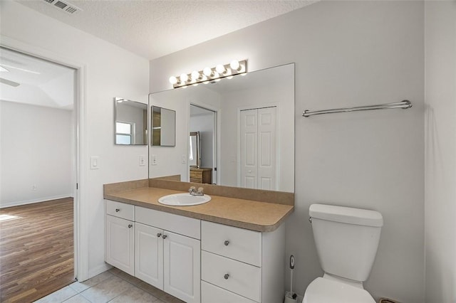 bathroom with vanity, tile patterned floors, toilet, and a textured ceiling