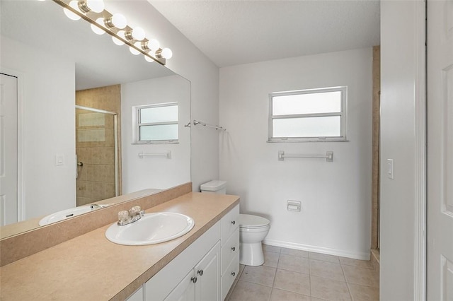 bathroom with tile patterned flooring, toilet, a healthy amount of sunlight, and tiled shower