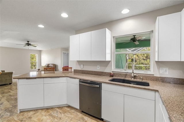 kitchen featuring dishwashing machine, sink, kitchen peninsula, and white cabinets