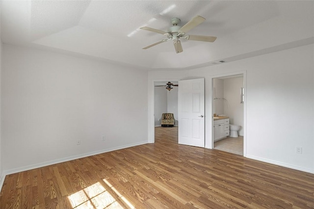 unfurnished bedroom featuring ceiling fan, light wood-type flooring, and ensuite bath