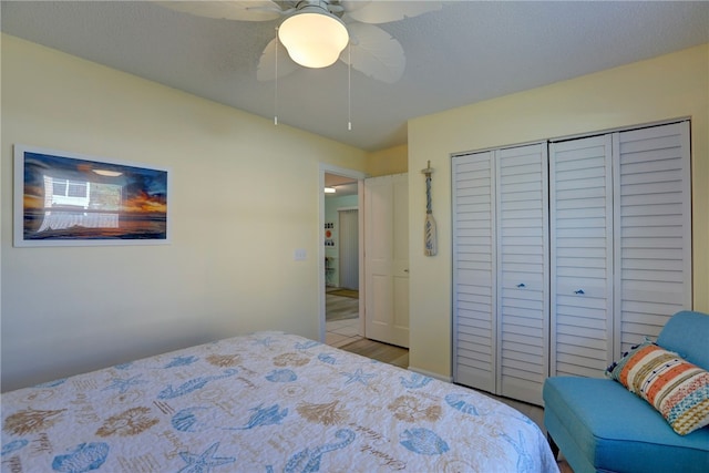 bedroom with a closet, wood finished floors, a textured ceiling, and ceiling fan