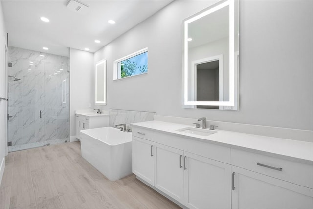 129 Strand Dr, Vero Beach, FL 32963 - full bathroom featuring a sink, a marble finish shower, recessed lighting, and wood finished floors