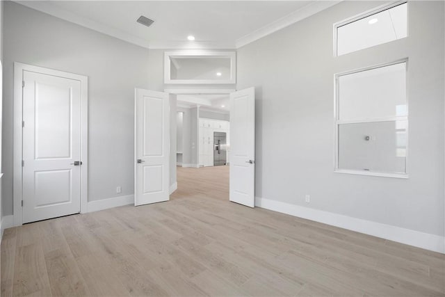 129 Strand Dr, Vero Beach, FL 32963 - unfurnished bedroom with crown molding, baseboards, visible vents, and light wood finished floors