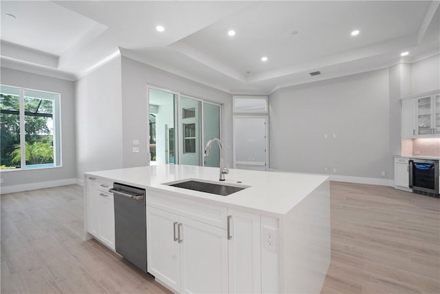 129 Strand Dr, Vero Beach, FL 32963 - kitchen featuring a tray ceiling, a sink, light wood finished floors, and wine cooler