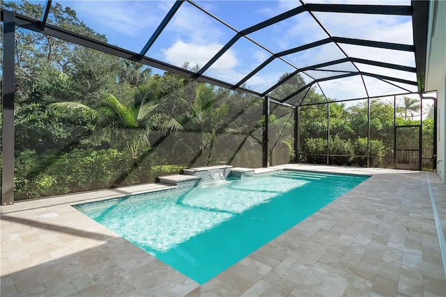 view of pool featuring pool water feature, glass enclosure, and a patio