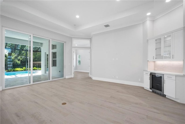 129 Strand Dr, Vero Beach, FL 32963 - unfurnished living room with a dry bar, light wood-type flooring, baseboards, wine cooler, and recessed lighting