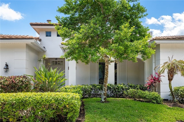 8455 Bay Leaf Ln Unit 11, Vero Beach, FL 32963 - view of front of property with a tiled roof, stucco siding, and a front lawn