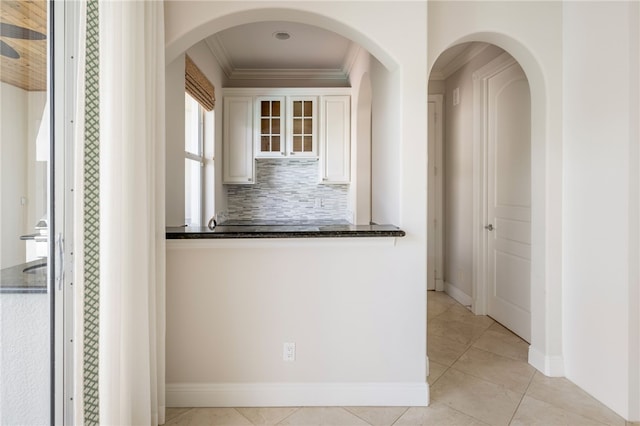 8455 Bay Leaf Ln Unit 11, Vero Beach, FL 32963 - hall with crown molding, baseboards, arched walkways, and light tile patterned flooring