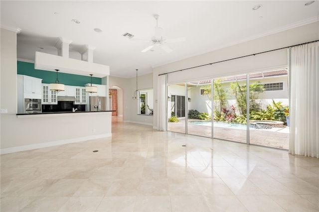8455 Bay Leaf Ln Unit 11, Vero Beach, FL 32963 - unfurnished living room with ceiling fan, arched walkways, ornamental molding, baseboards, and a towering ceiling