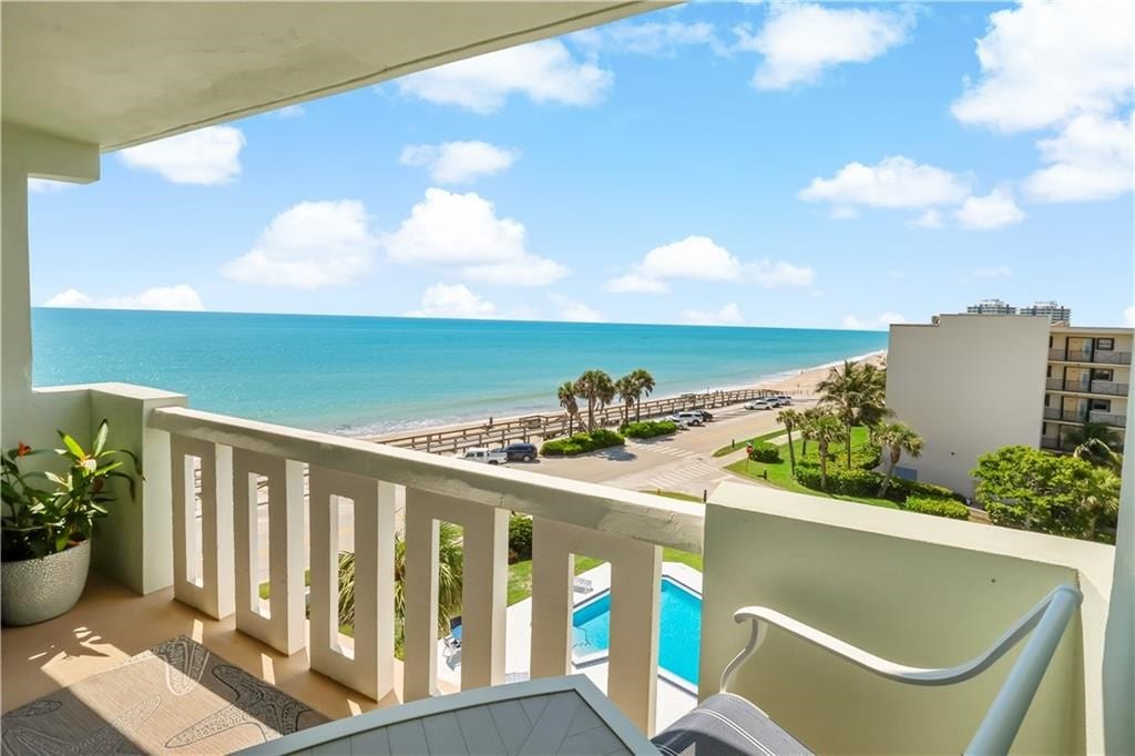 balcony featuring a water view and a beach view