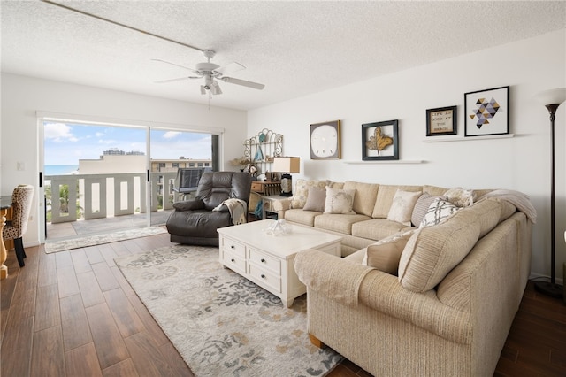 living room featuring ceiling fan, wood-type flooring, and a textured ceiling