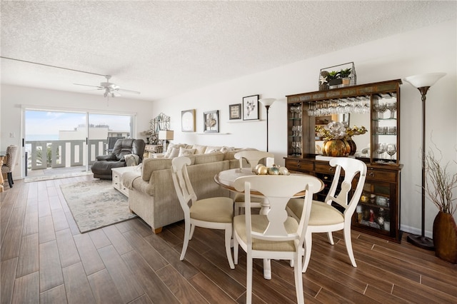 dining space featuring a textured ceiling, dark hardwood / wood-style floors, and ceiling fan