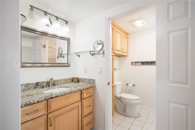 bathroom featuring vanity, tile patterned flooring, and toilet