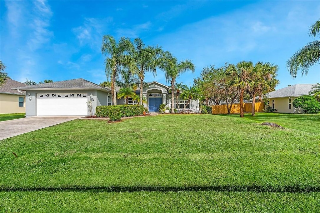 ranch-style house featuring a garage and a front lawn