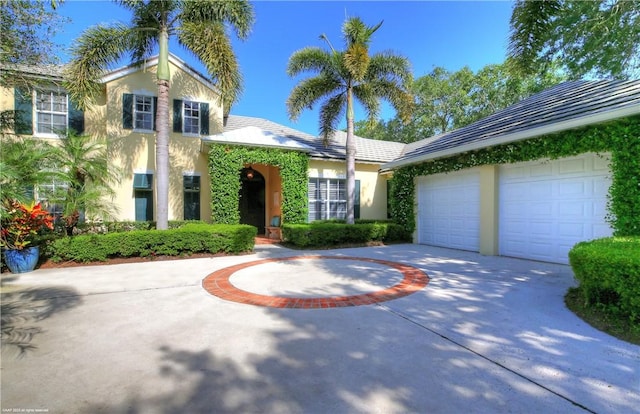 425 Indies Dr, Vero Beach, FL 32963 - view of front of home with stucco siding, an attached garage, and concrete driveway
