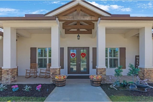 entrance to property with covered porch and french doors