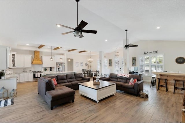 living room featuring ceiling fan, vaulted ceiling, and light wood-type flooring