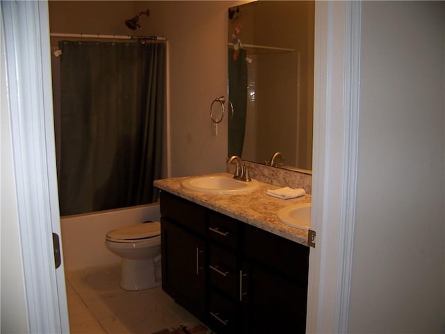 full bathroom with double vanity, toilet, shower / bath combo, and a sink