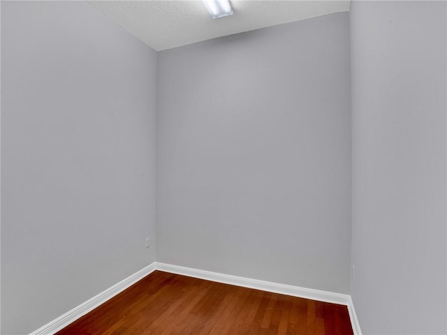 unfurnished room featuring hardwood / wood-style flooring and a textured ceiling