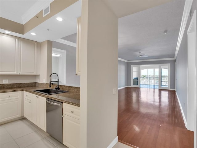 kitchen with dishwasher, white cabinets, crown molding, and sink