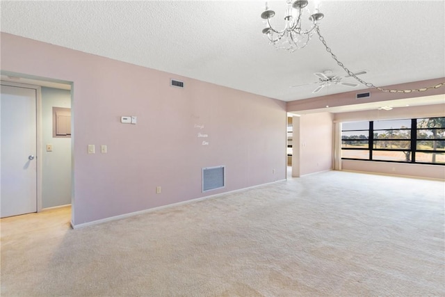 unfurnished living room featuring ceiling fan with notable chandelier, a textured ceiling, and light carpet