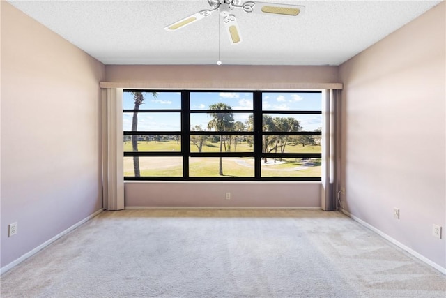 spare room featuring ceiling fan, light colored carpet, and a textured ceiling