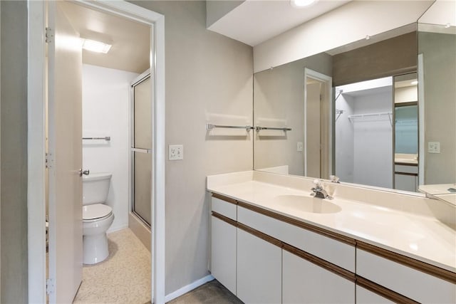 bathroom featuring vanity, toilet, and walk in shower