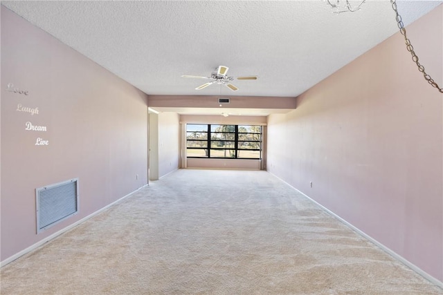 carpeted spare room with a textured ceiling and ceiling fan