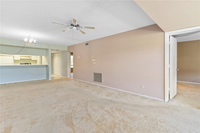 unfurnished living room featuring light carpet and ceiling fan with notable chandelier